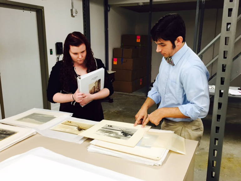 PRINTS IN PROGRESS: As part of her internship with the Chrysler Museum, Stephanie Deach '17 worked alongside Brock Curator of American Art Alex Mann to evaluate and select photographs for the Harry Cowles Mann exhibition. (Photo by Kathleen Casey)