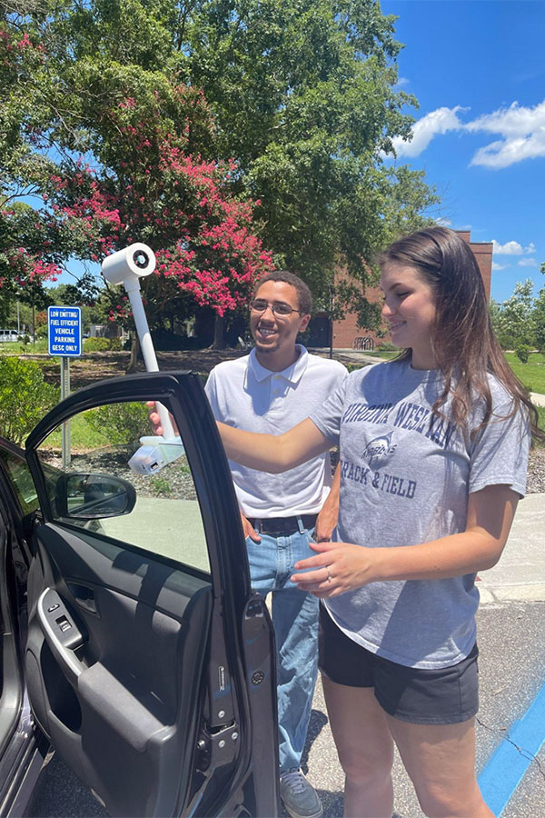 Virginia Wesleyan University students mount the temperature sensor to a car.